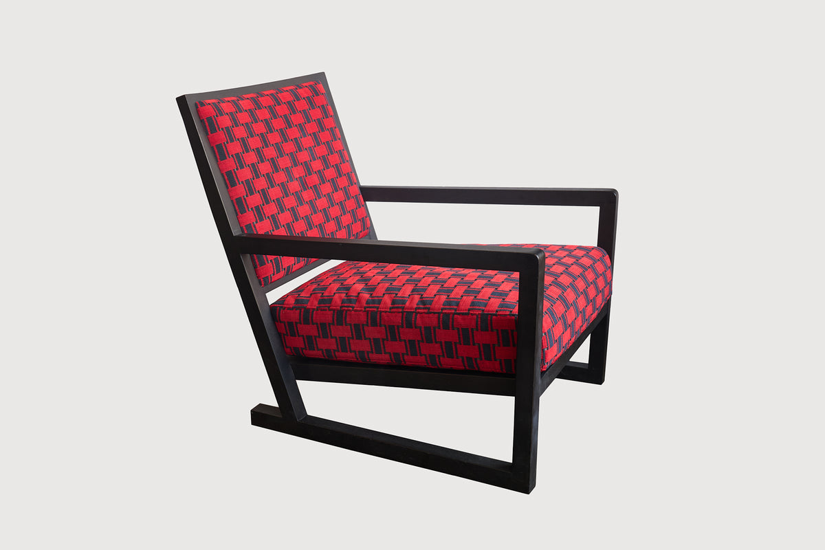 Chair with red patterned seat and black frame on a light gray background
