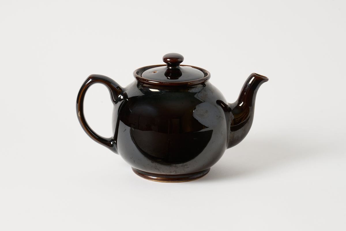 A glossy dark brown ceramic teapot with a matching lid, shown on a clean light gray background.