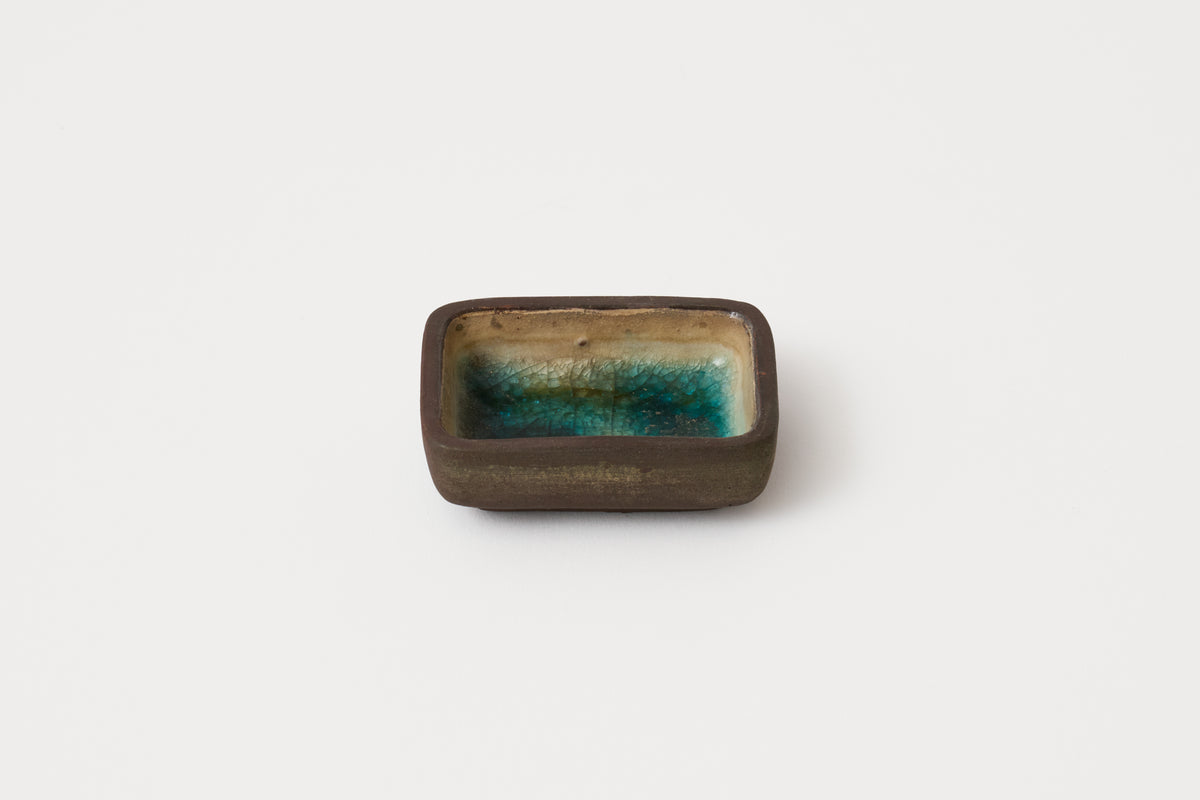 Rectangular ceramic dish with a greenish-brown glaze on a white background